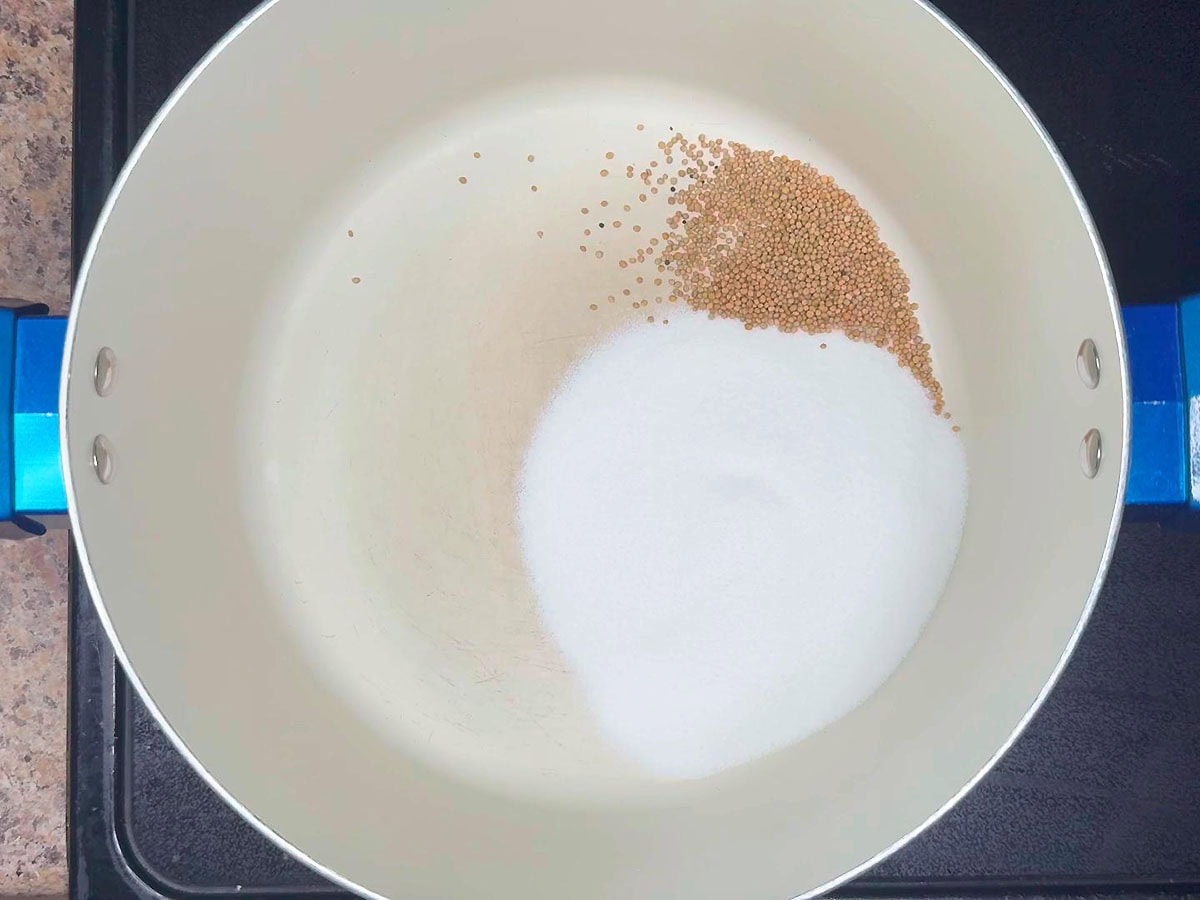 Mustard seeds added to the sugar in a stockpot.