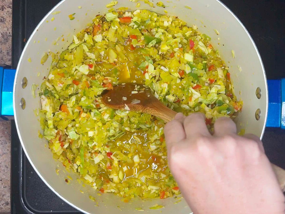 Stirring the chopped vegetables into the brine.