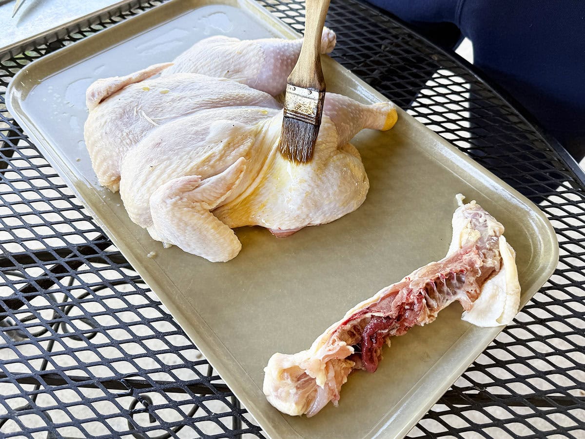 Brushing the outside of the chicken with olive oil.