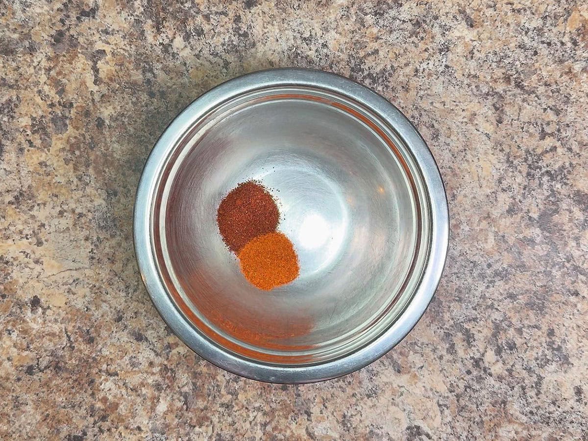 Chili powder and paprika in a small mixing bowl.