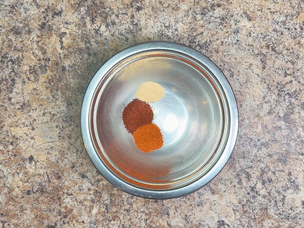 Chili powder, paprika, and garlic powder in a small mixing bowl.