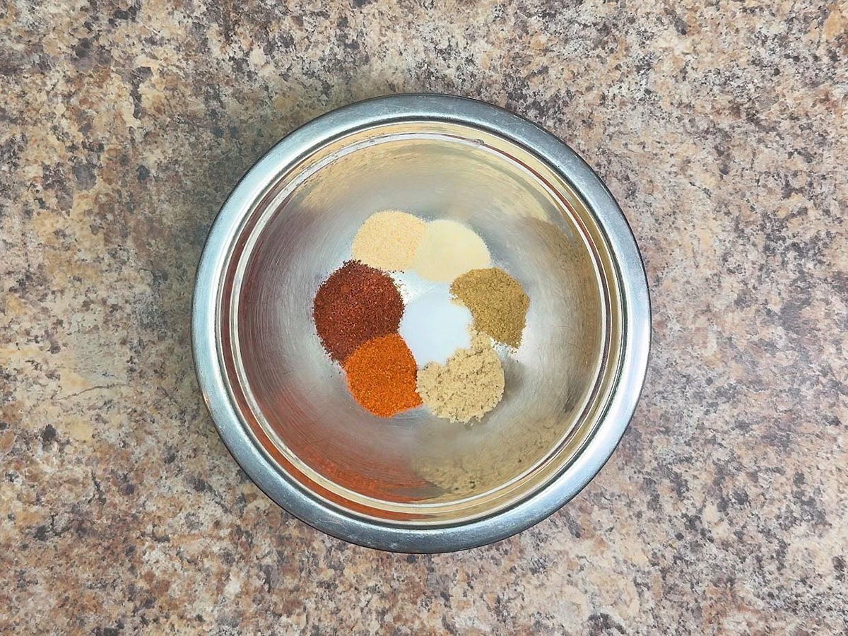 Chili powder, paprika, garlic powder, onion powder, cumin, brown sugar, and salt in a small mixing bowl.
