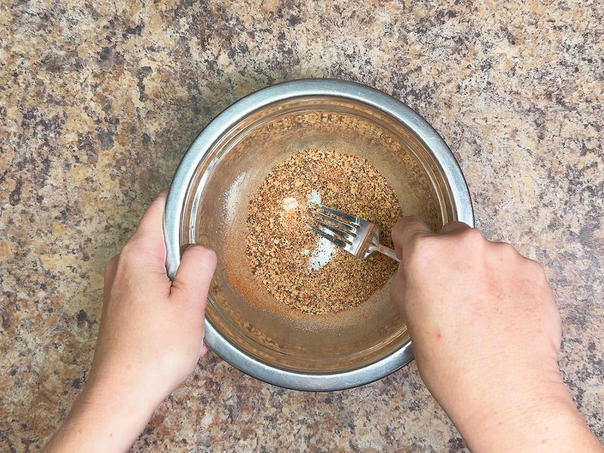Using a fork to mix the chili rub ingredients together.