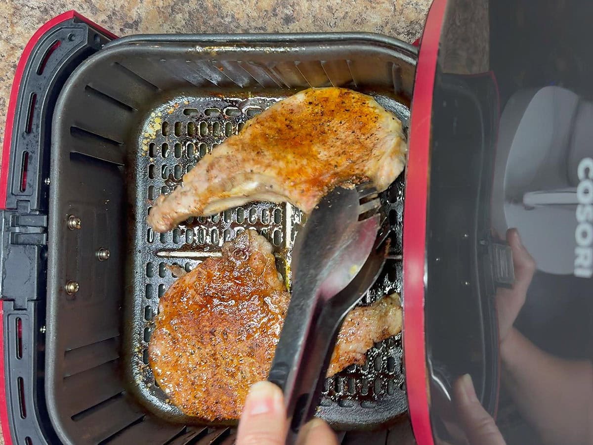 Flipping the pork chops halfway through the cook time.