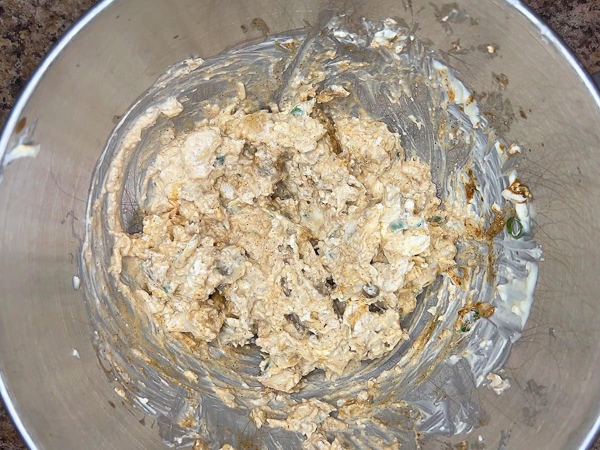 Cajun catfish dip ingredients mixed together in a mixing bowl.