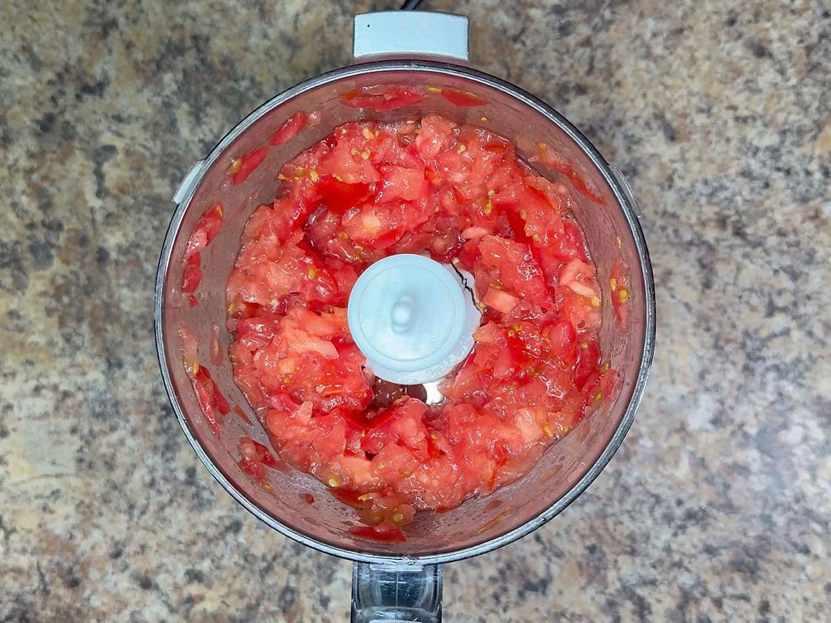 Chopped tomatoes in a food processor.