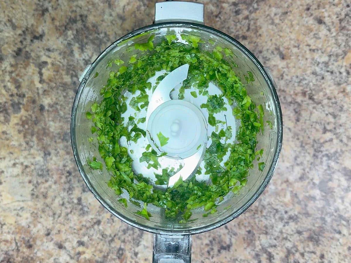Chopped cilantro in a food processor.