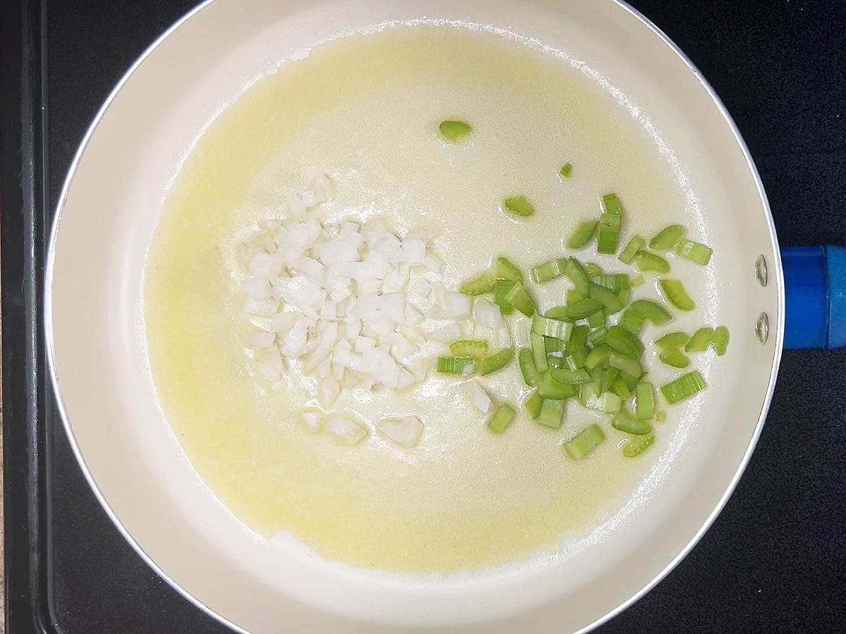 Diced onion and celery in a skillet with melted butter.