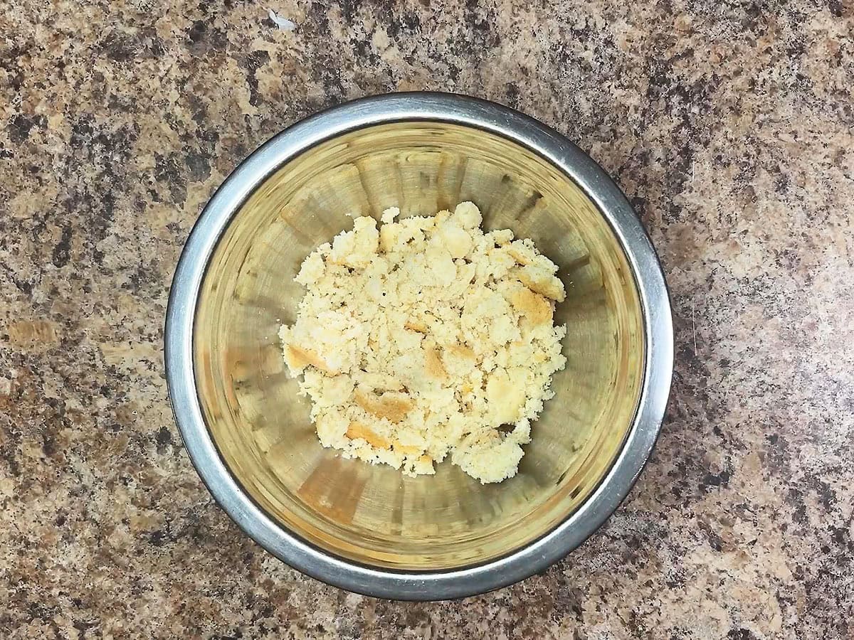 Crumbled cornbread in a small mixing bowl.