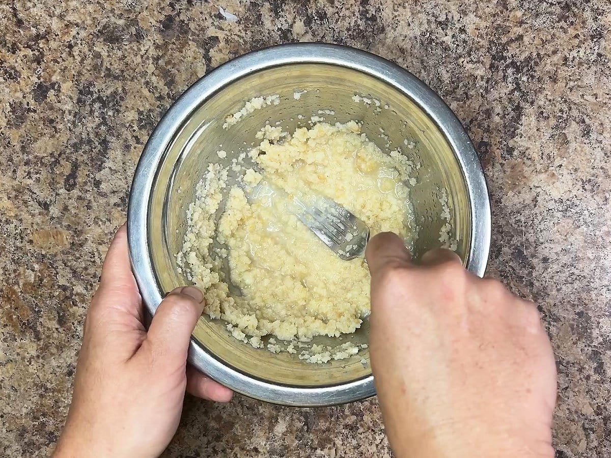 Mashing the crumbled cornbread into the chicken broth.