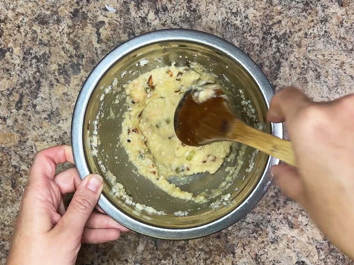 Mixing together the cornbread stuffing ingredients in a small mixing bowl.