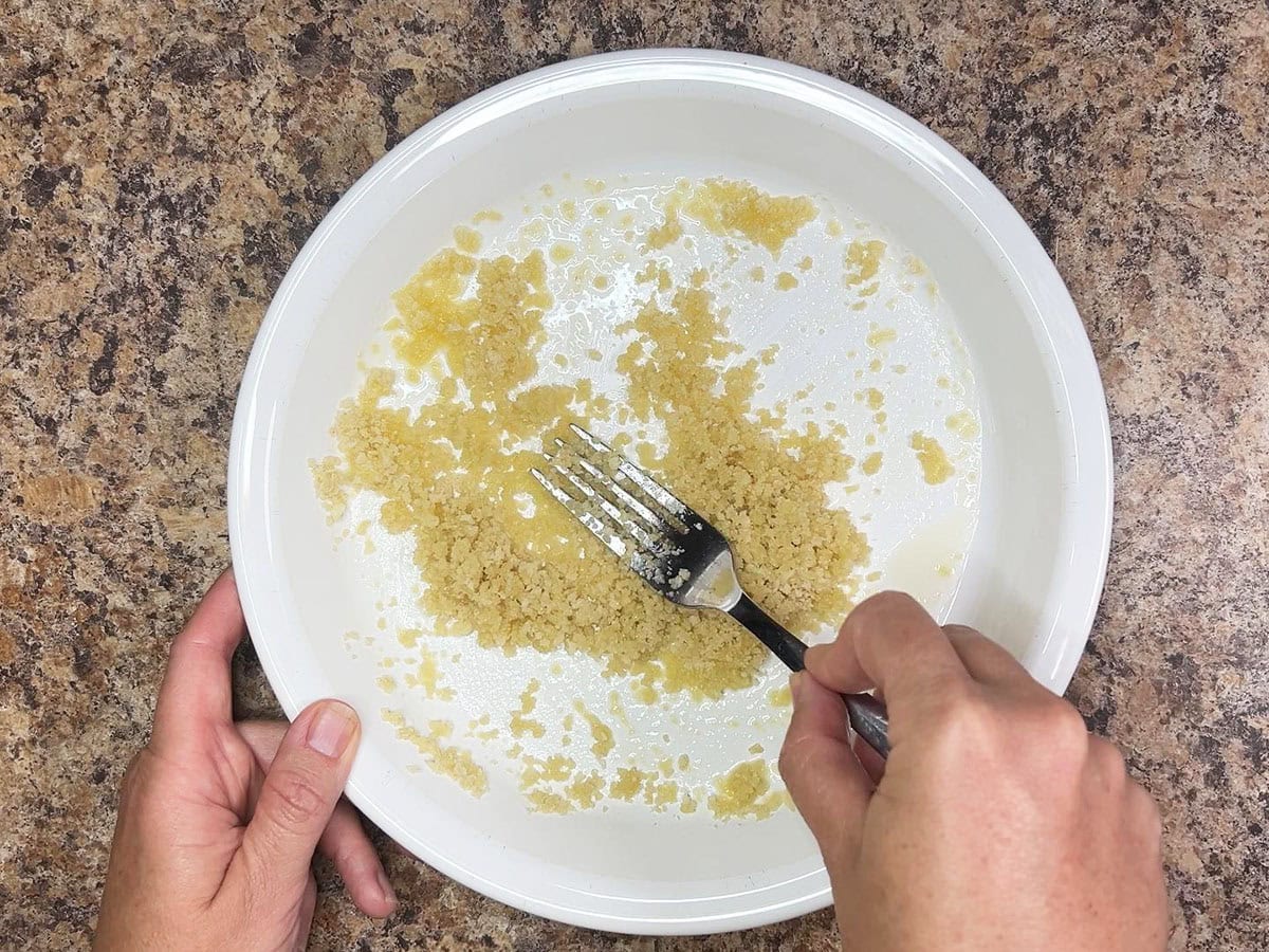 Stirring together the Panko bread crumbs and melted butter in a shallow dish.