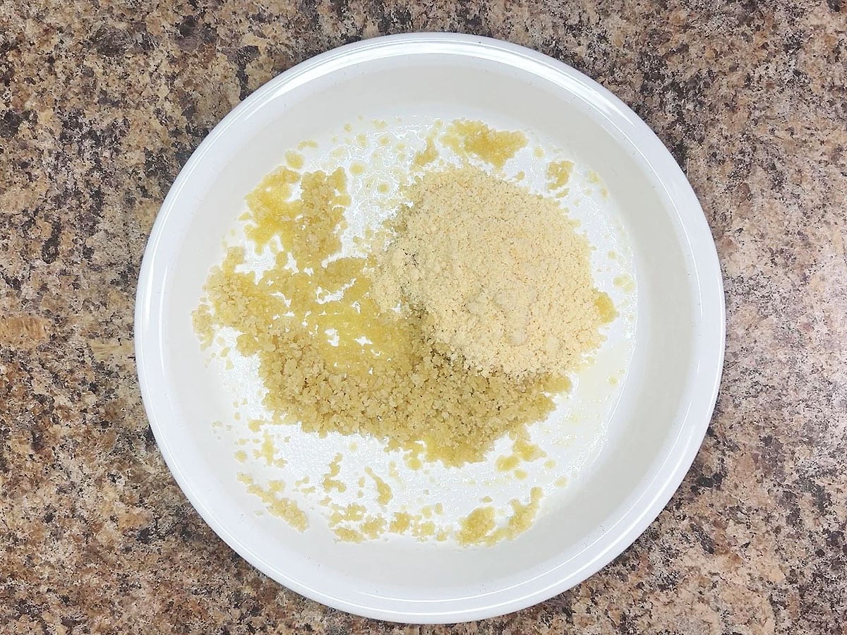 Panko bread crumbs coated in butter with Parmesan cheese in a shallow dish.