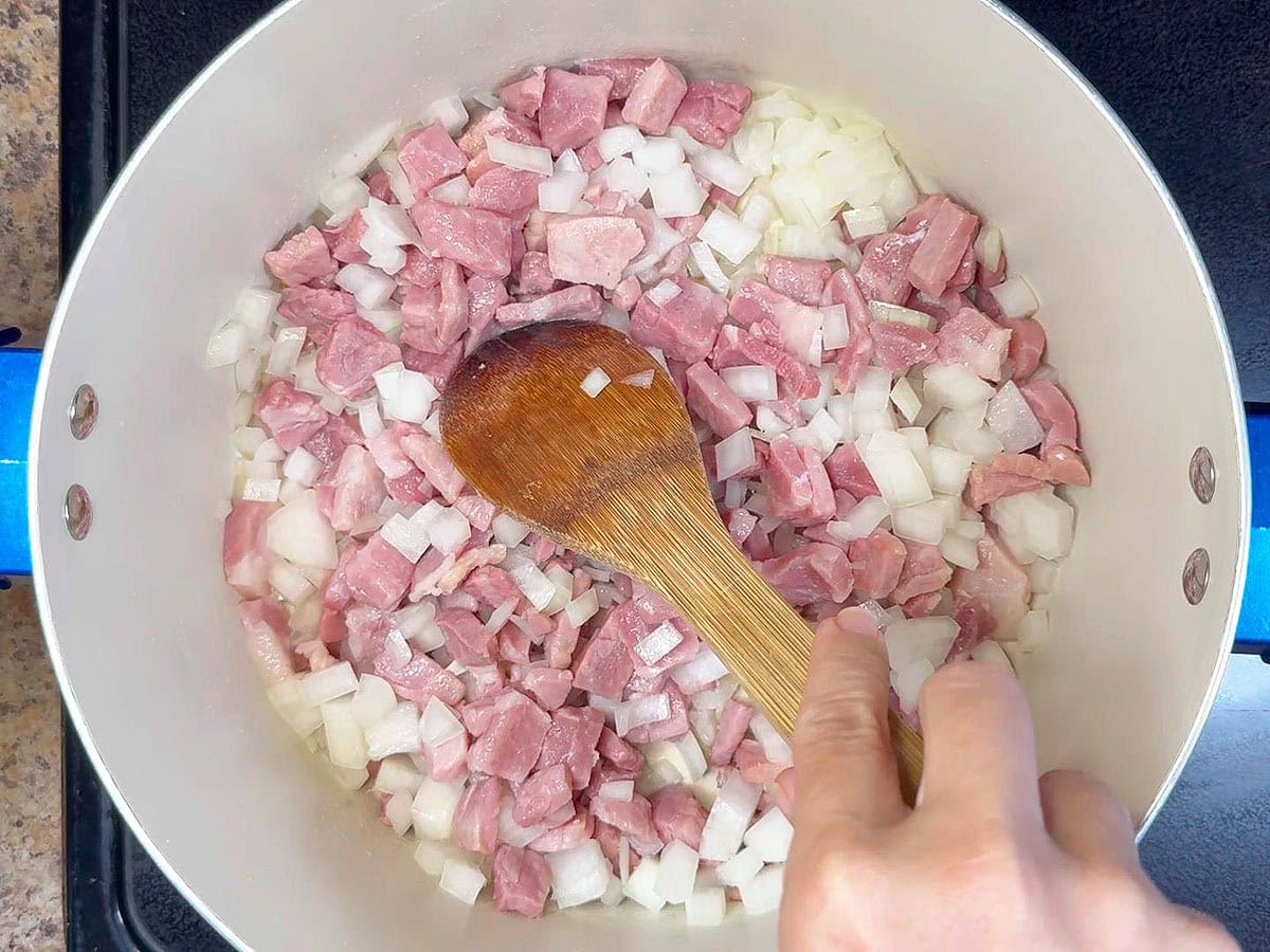 Stirring the diced onions and country ham while sauteing for 10 minutes.