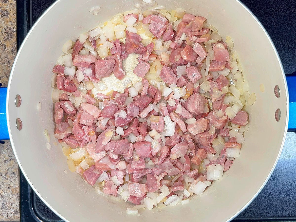 Country ham and diced onions after they have cooked for 10 minutes.