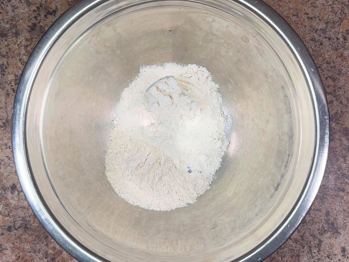 Flour and white cornmeal in a large mixing bowl.