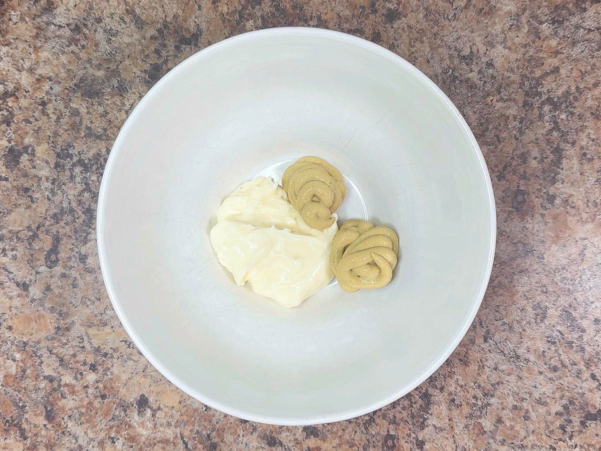 Mayonnaise and Dijon mustard in a mixing bowl.