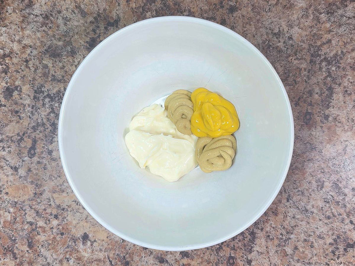 Mayonnaise, Dijon mustard, and yellow mustard in a mixing bowl.