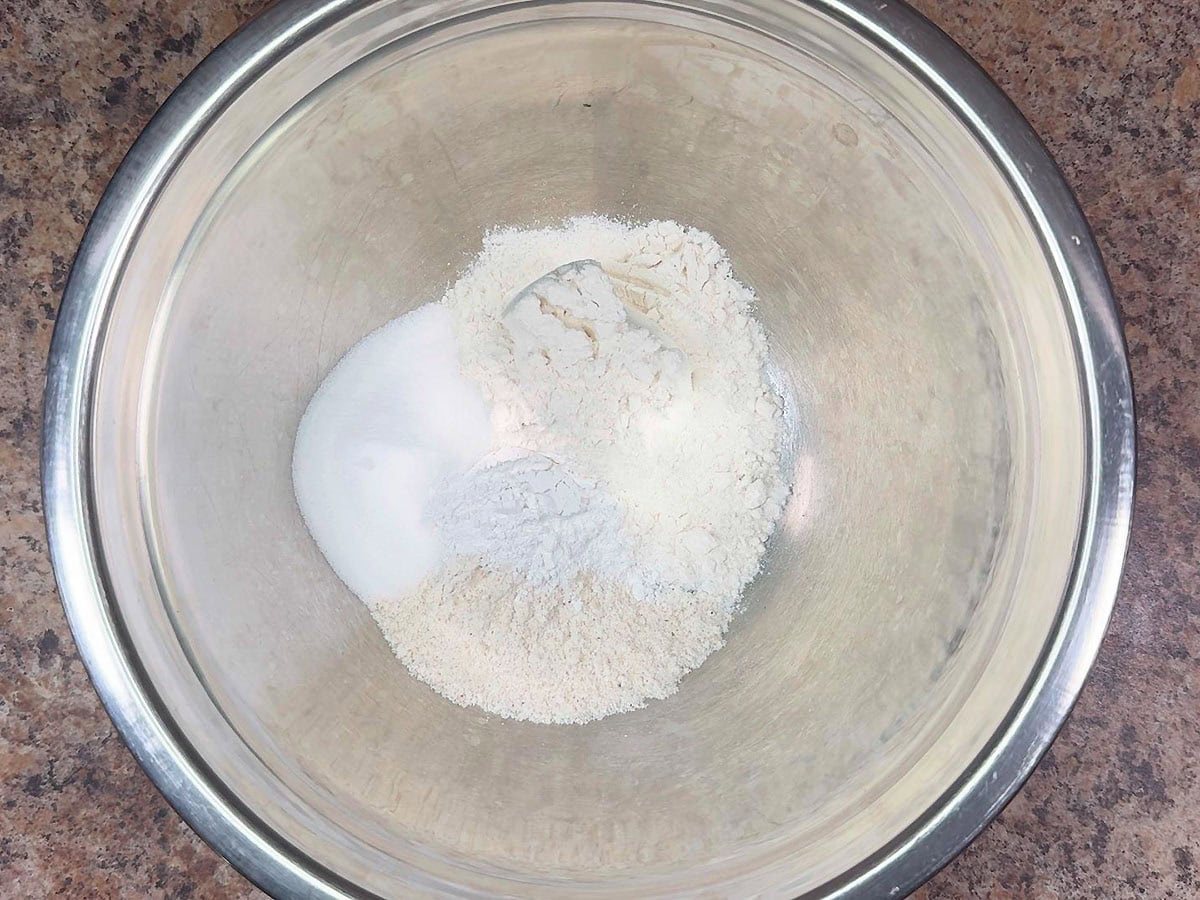 Flour, white cornmeal, sugar, and baking powder in a large mixing bowl.
