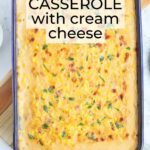 Baked cheesy corn casserole garnished with parsley in a rectangular baking dish.