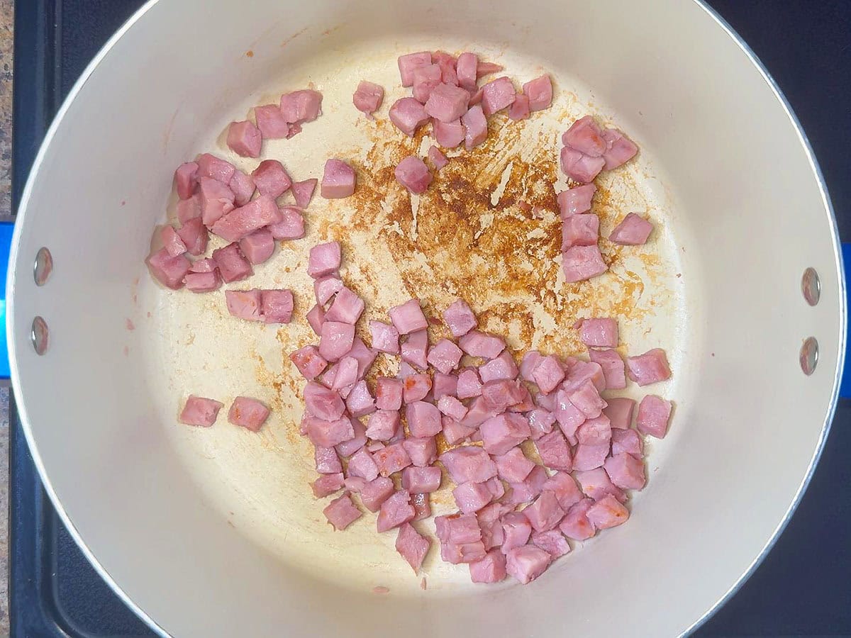 Diced ham browning in a large pot.
