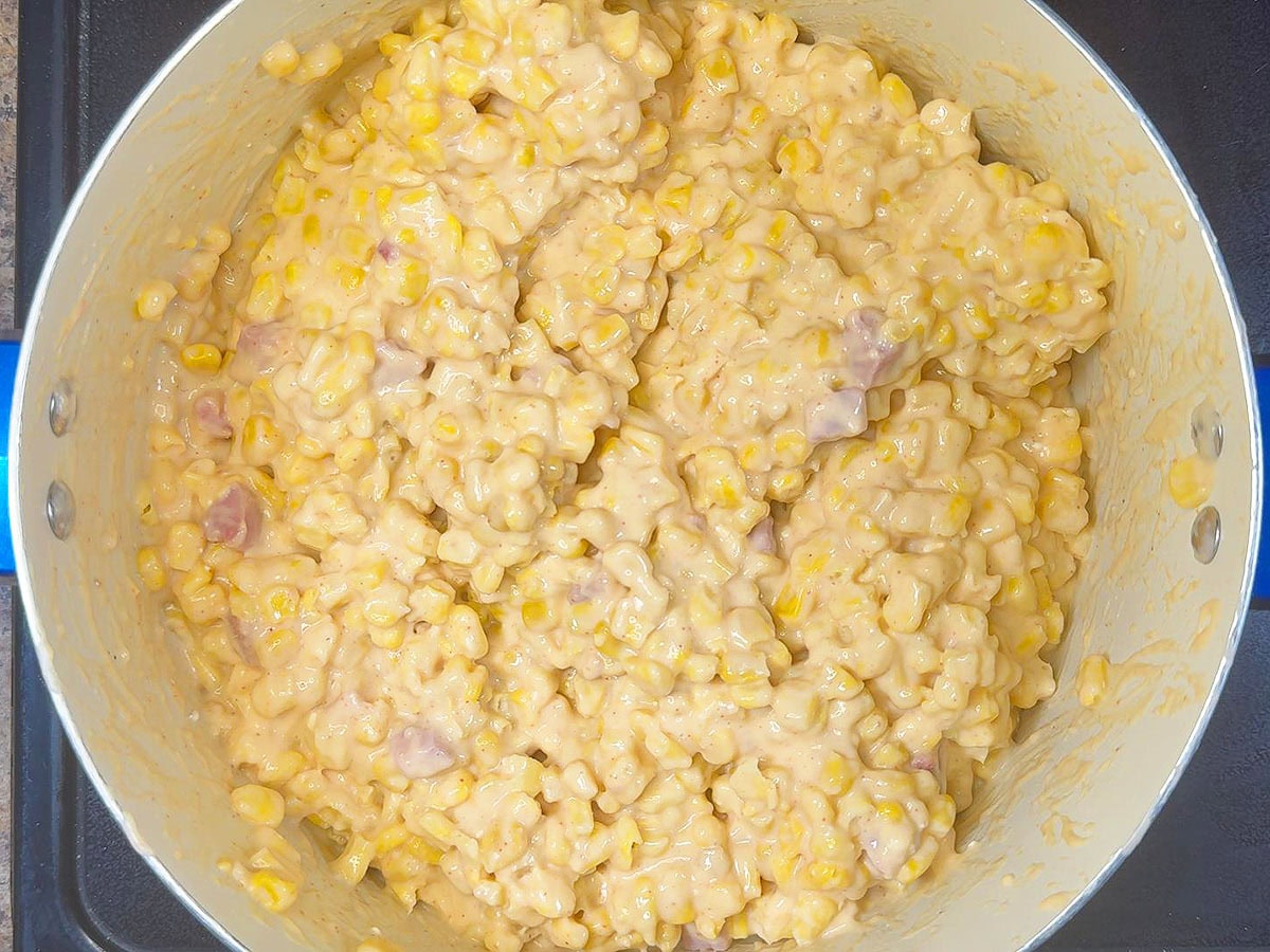 Whole kernel corn added to the pot and coated with the ham and cheese sauce.