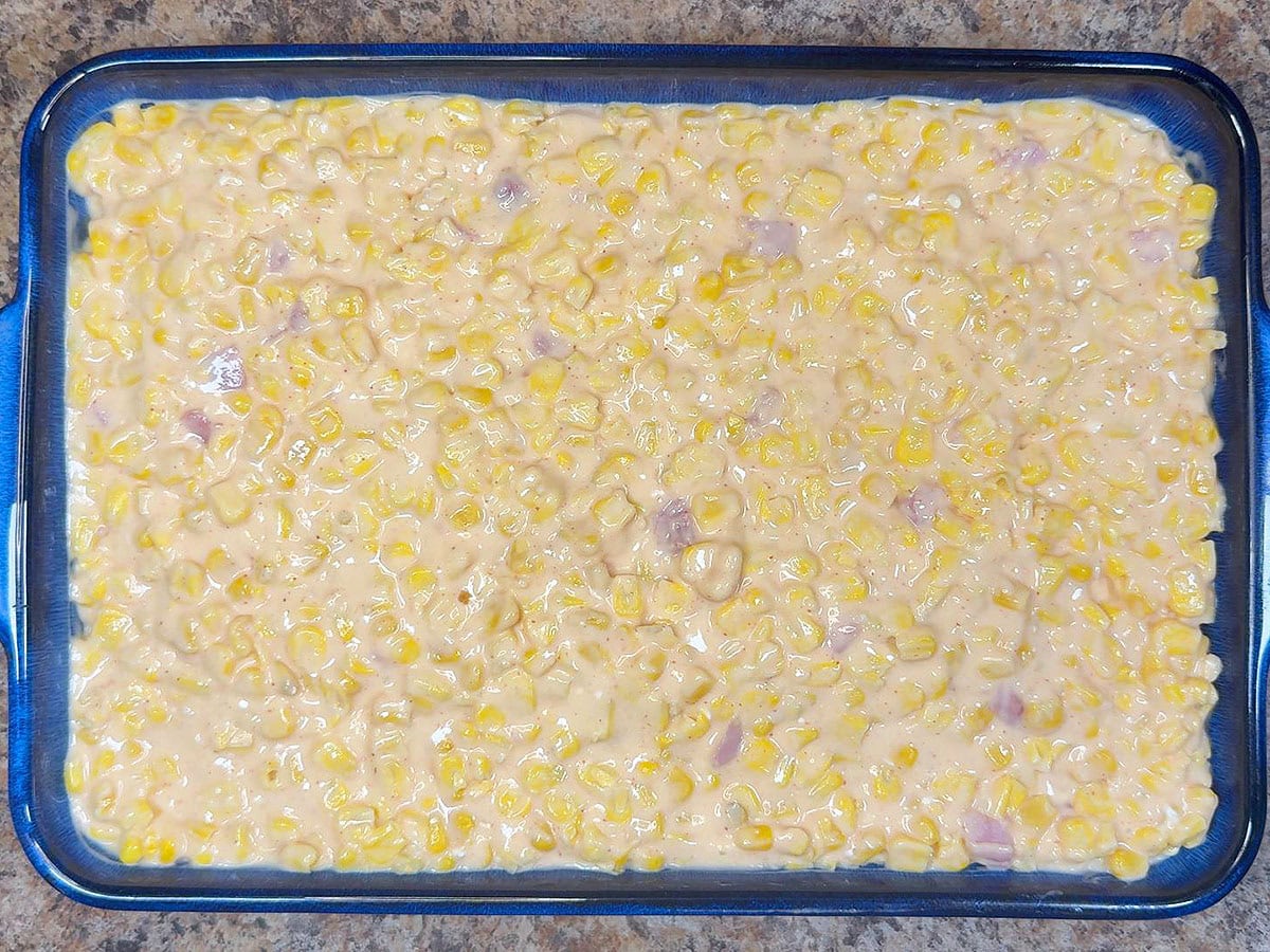 Cheesy corn casserole spread into the bottom of a greased casserole dish.