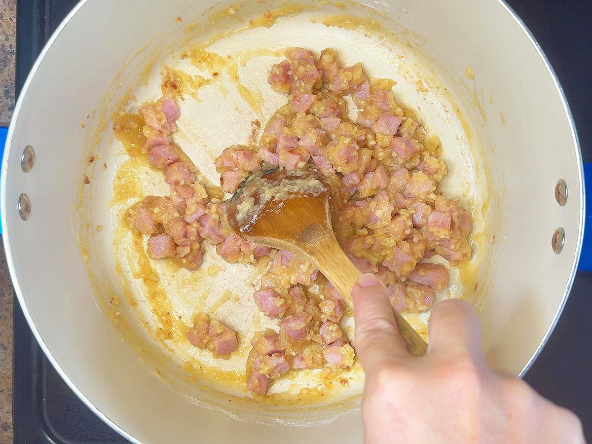 Stirring garlic and flour into the cooked and diced ham.