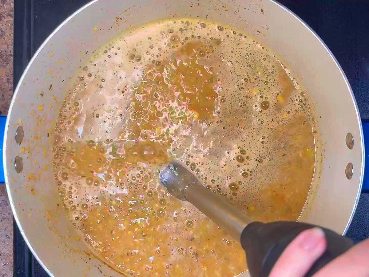 Using an immersion blender to puree the bisque.