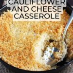 Mashed cauliflower and cheese casserole topped with Panko breadcrumbs in a cast iron skillet with a serving spoon.