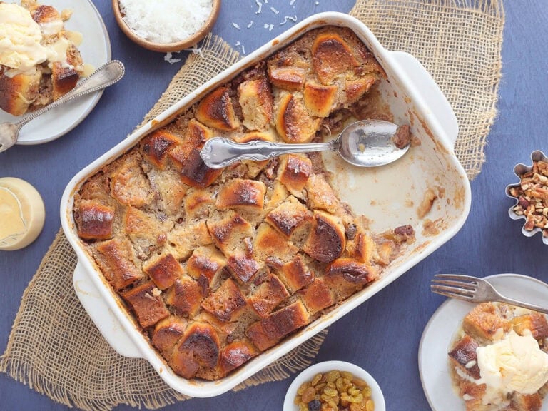Pan of pina colada pineapple raisin bread pudding with a slice removed.