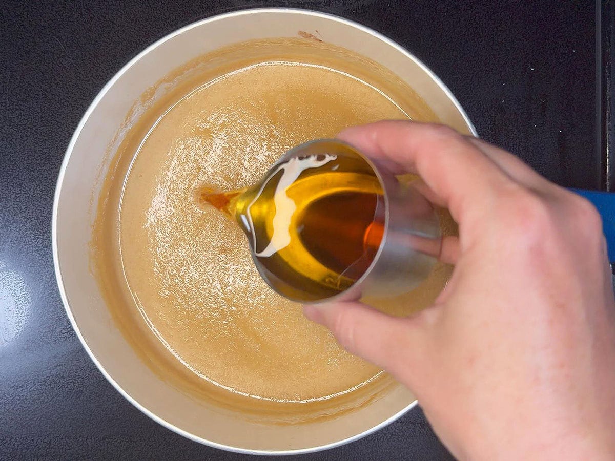 Adding rum to the rum sauce.