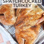 Smoked spatchcocked turkey resting on a rack on a foil lined baking sheet.