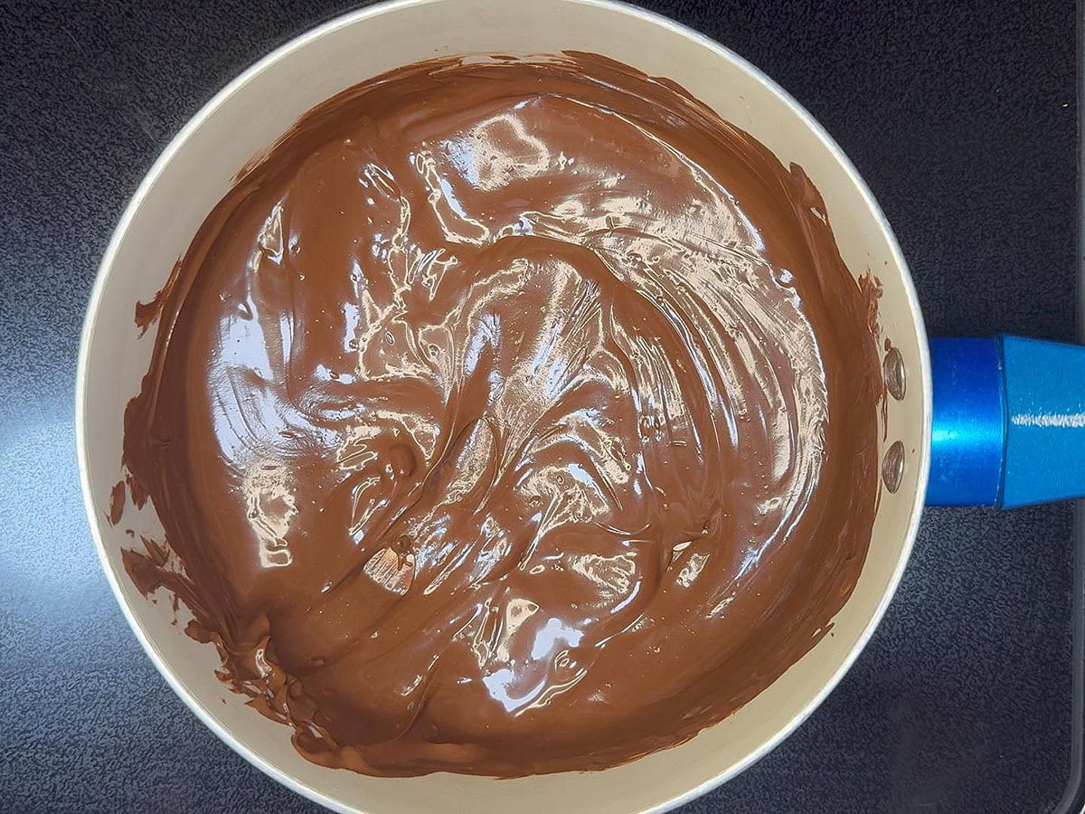Melted chocolate in a small saucepan.