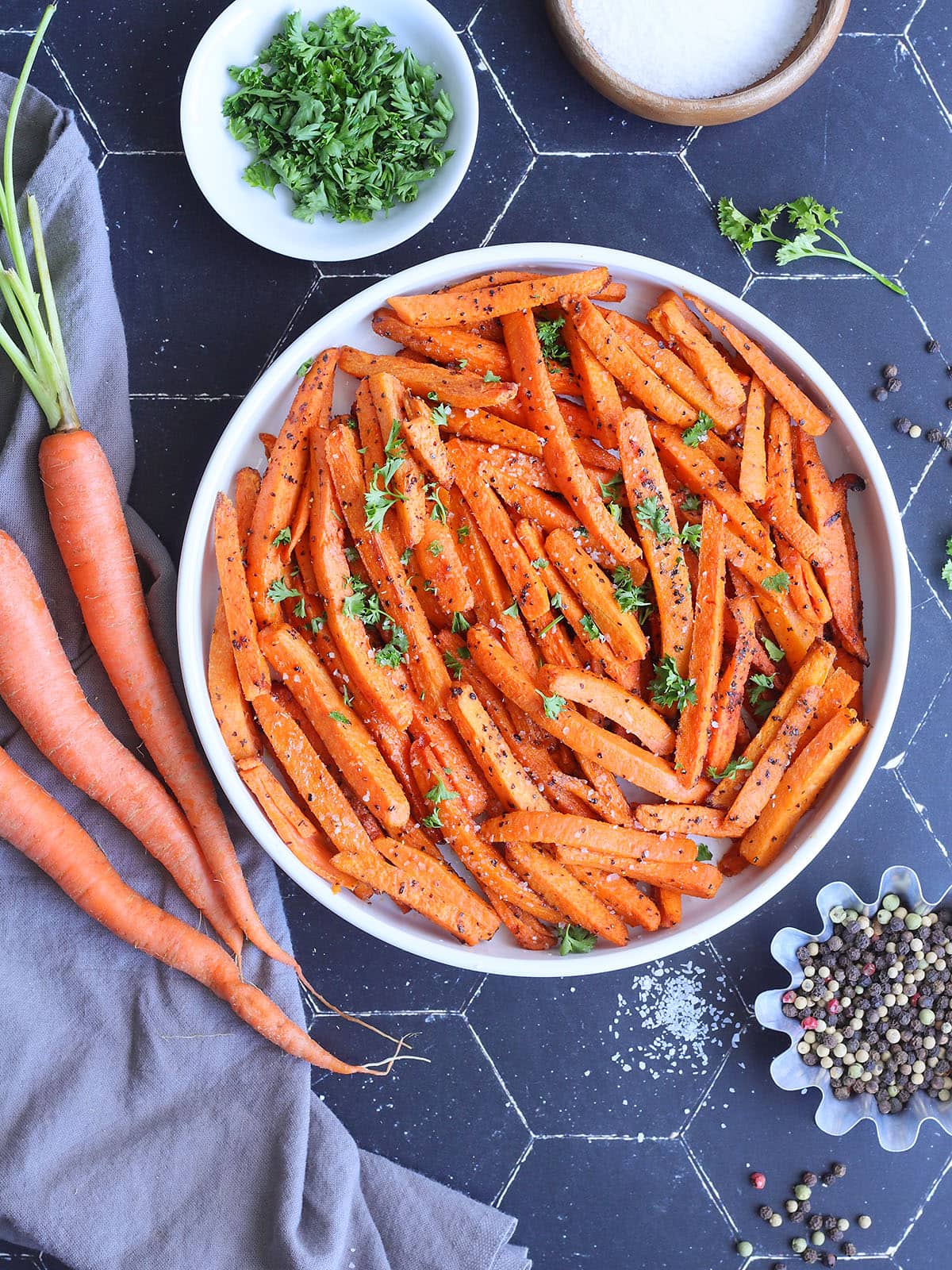 Serving dish of air fryer roasted carrots garnished with fresh parsley.