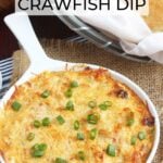 Dish of hot baked crawfish dip garnished with sliced green onions surrounded by toasted baguettes and a Mason jar of iced tea.