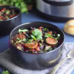 Bowl of Instant Pot Black Bean soup with Andouille garnished with fresh cilantro.