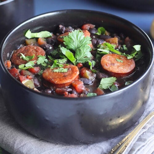 Bowl of Instant Pot Black Bean soup with Andouille garnished with fresh cilantro.