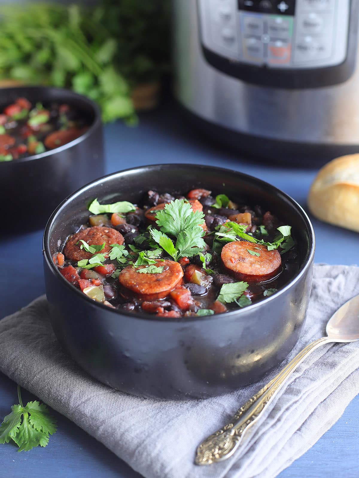 Bowl of Instant Pot Black Bean soup with Andouille garnished with fresh cilantro.