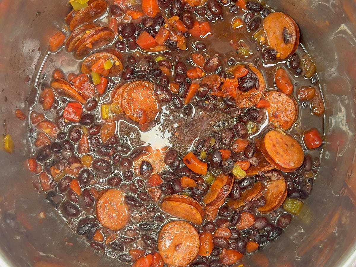 Instant Pot black beans soup with the diced tomatoes and green chilis and the sausage added back to the pot.