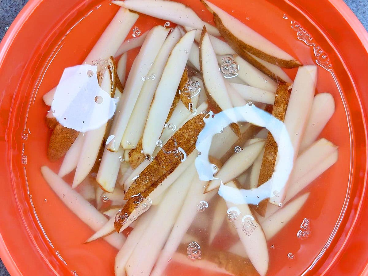Soaking cut potatoes in cold water.