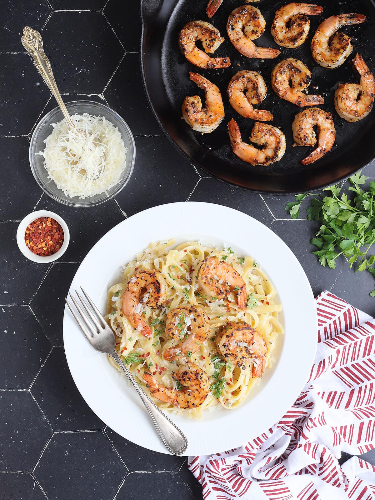 Blackened shrimp on a bed of fettuccine noodles coated in alfredo sauce.