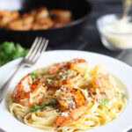 Blackened shrimp on a bed of fettuccine noodles coated in alfredo sauce.
