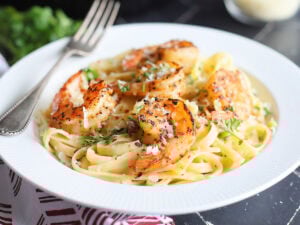 Blackened shrimp on a bed of fettuccine noodles coated in alfredo sauce.