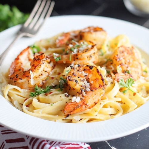 Blackened shrimp on a bed of fettuccine noodles coated in alfredo sauce.
