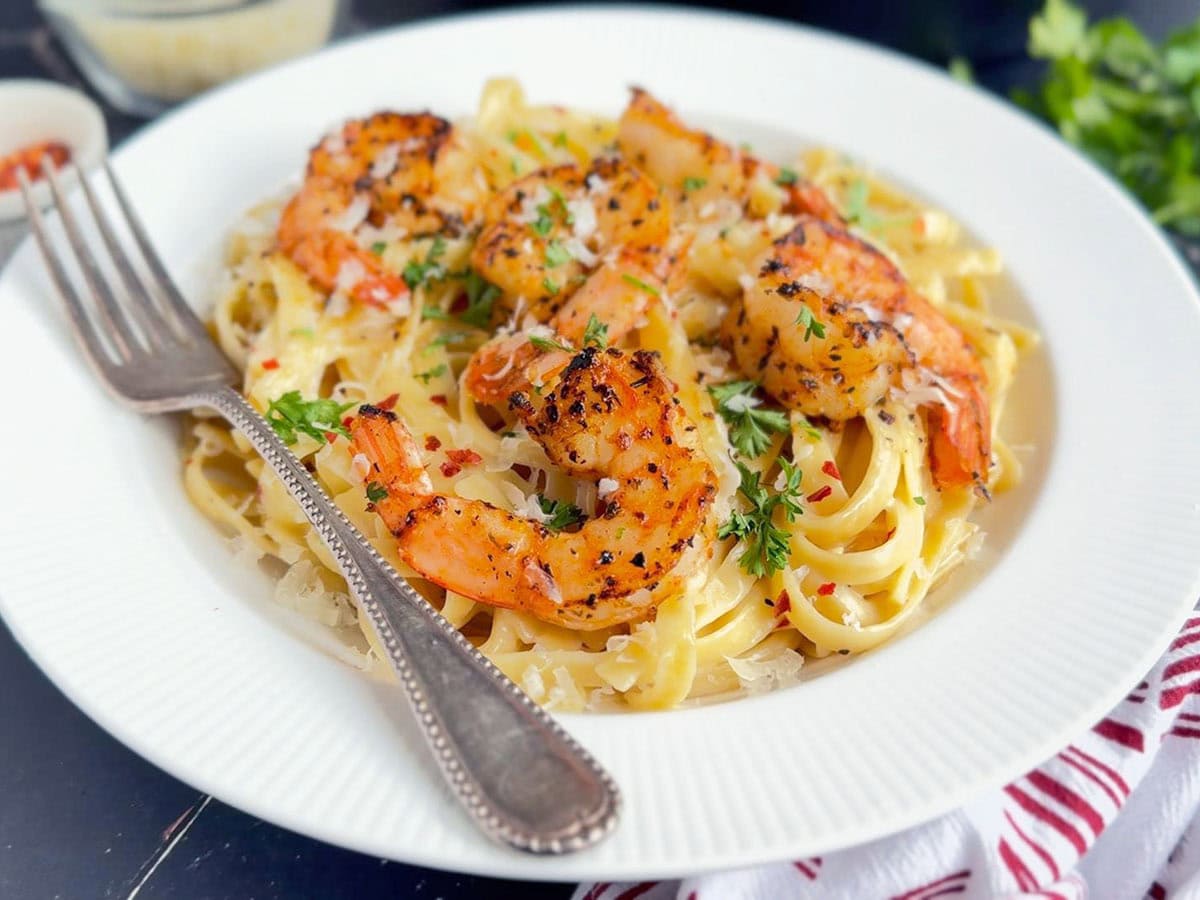 Blackened shrimp on a bed of fettuccine noodles.