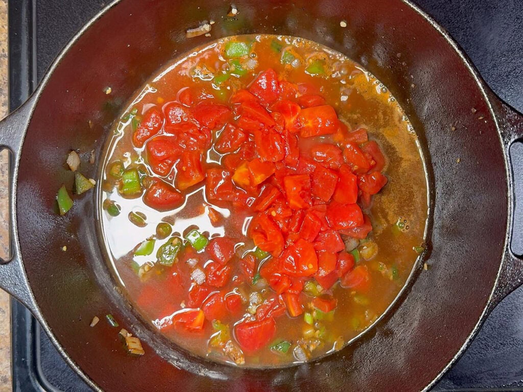 Diced tomatoes and beef broth added to the Dutch oven with the sauteed vegetables.