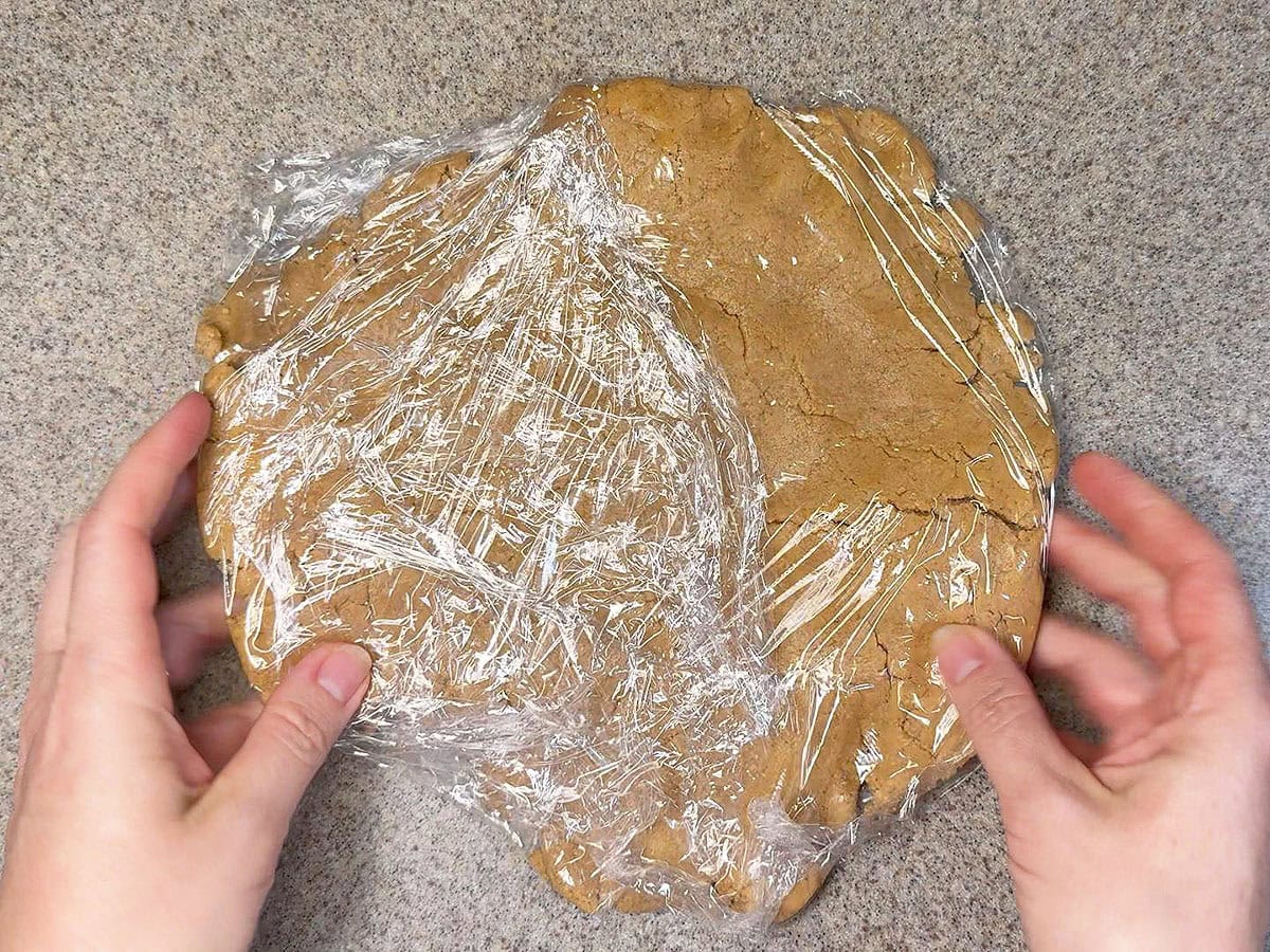 Wrapping the cookie dough in plastic wrap.