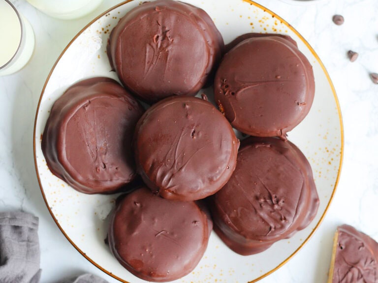 Plate of moonpies surrounded by a bowl of chocolate chips and bottles of milk.