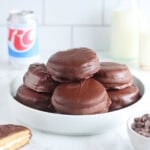 Plate of moonpies surrounded by a bowl of chocolate chips, bottles of milk, and an RC Cola.